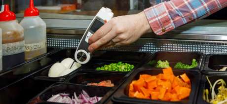 Someone testing food with a thermometer