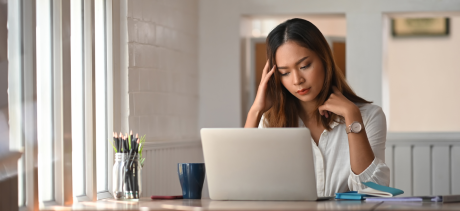 Woman looking at her laptop sad