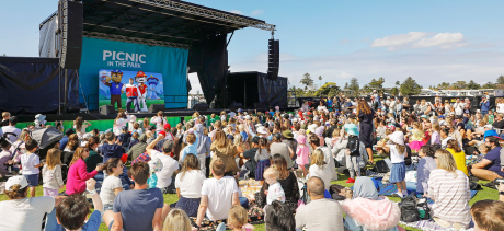 People outside watching the outdoor cinema with banners on display