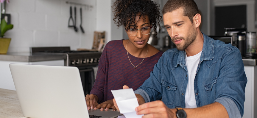 Couple looking at their laptop and a bill