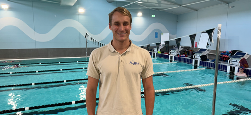 Allura Health co-founder Lachlan Bruce stands in front of an indoor swimming pool
