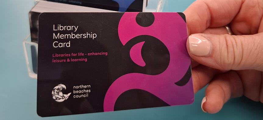 A hand holds a Northern Beaches Council library card