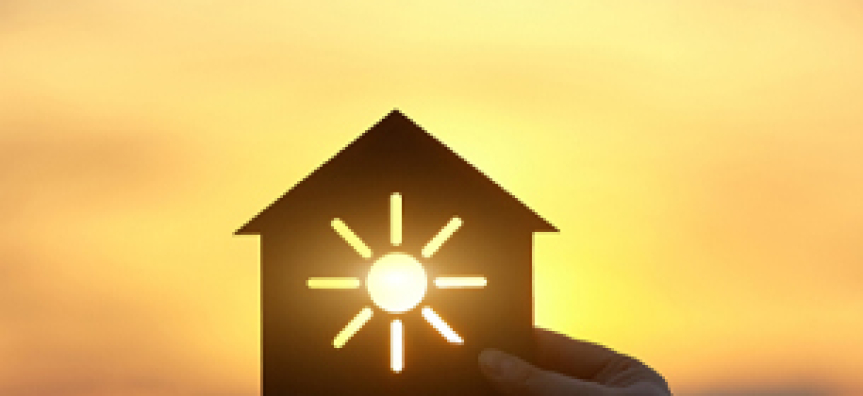House being held in front of the sun by a hand