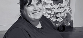 photo of Jodie smiling, sitting in the art gallery