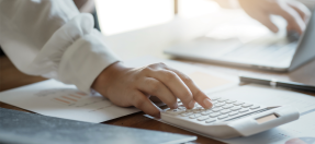 Person typing on a calculator