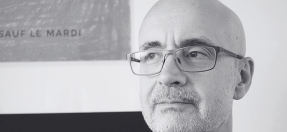 Close up photo of Darren Heinrich looking ponderously into the distance. 