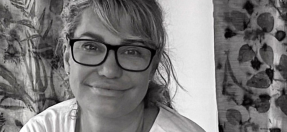 Portrait of Heidi, wearing glasses and smiling. 