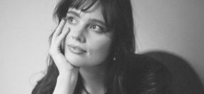 Kristina Wilson, resting her chin on her hand, looking into the distance. 