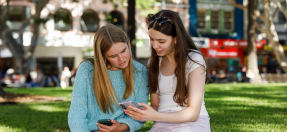 Two teenage girls using mobile phones